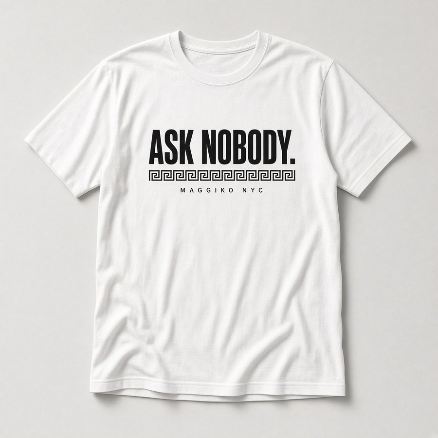 White t-shirt printed with ASK NOBODY. in black type over a thin Greek key band and MAGGIKO NYC